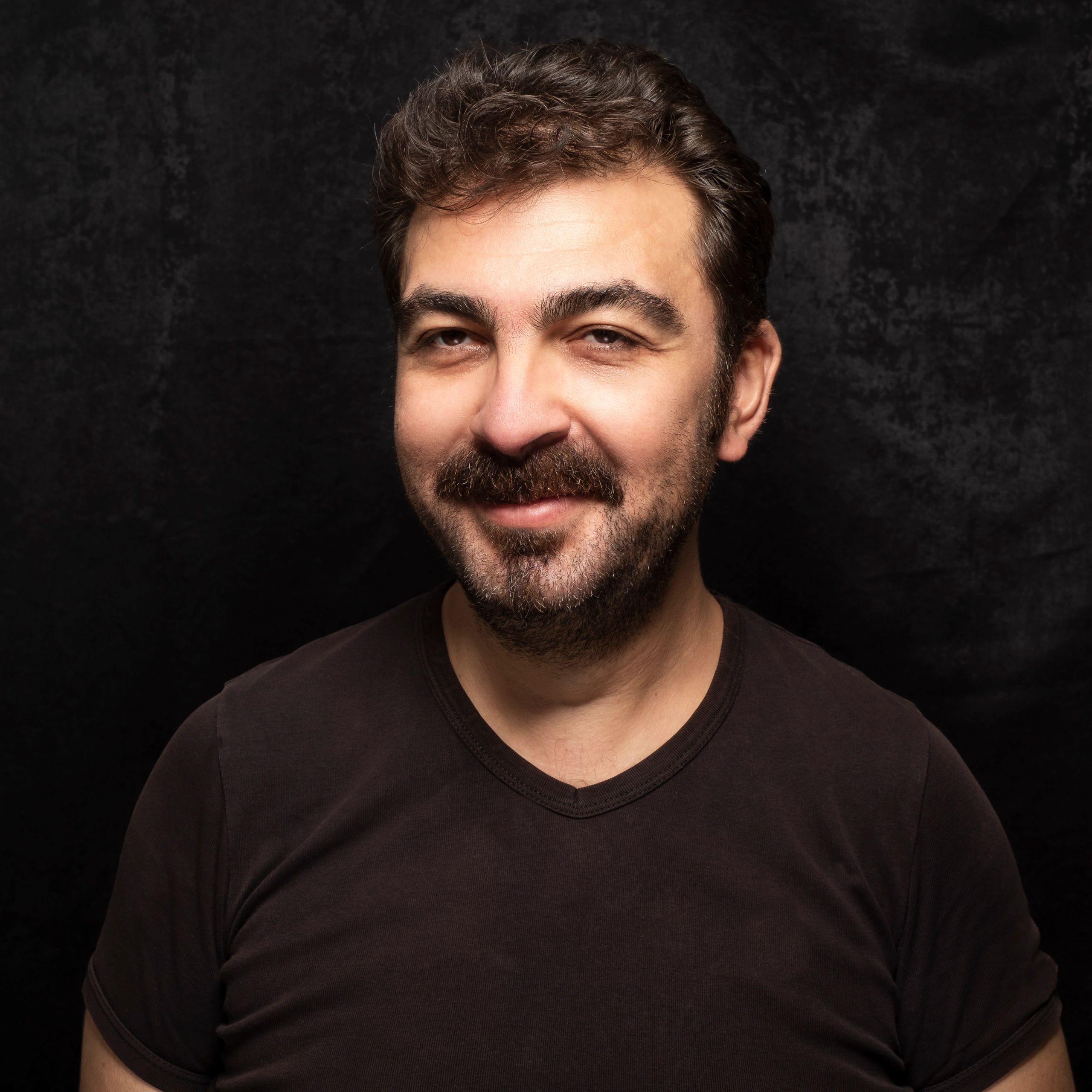 Portrait headshot of a man on a dark background