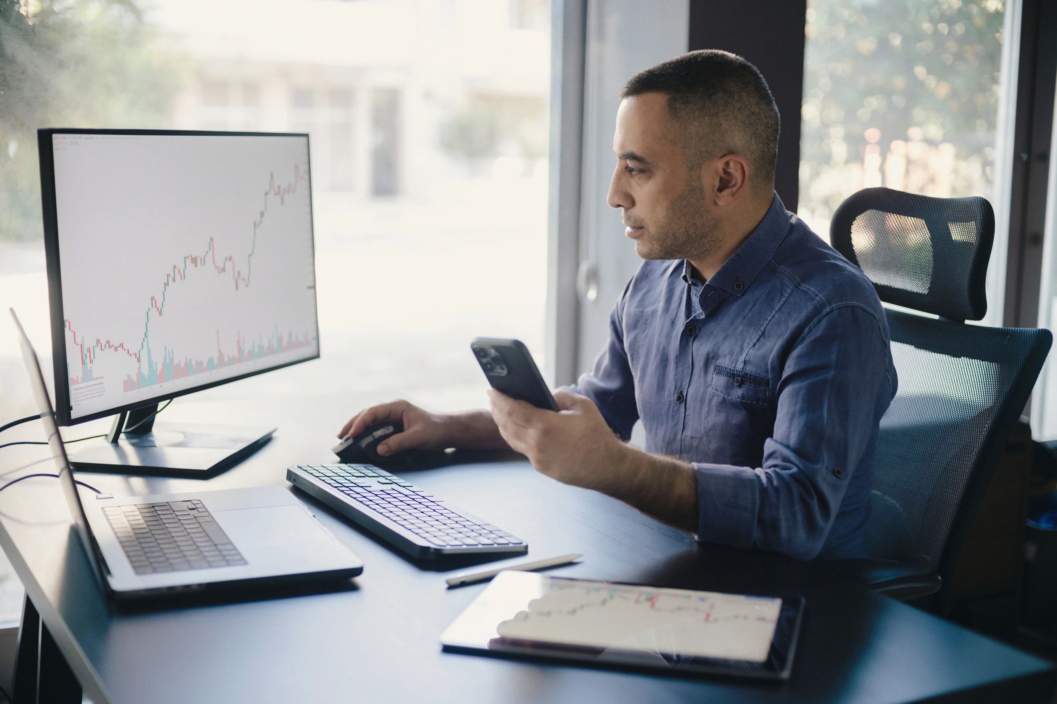 Trader reviewing market charts on multiple monitors